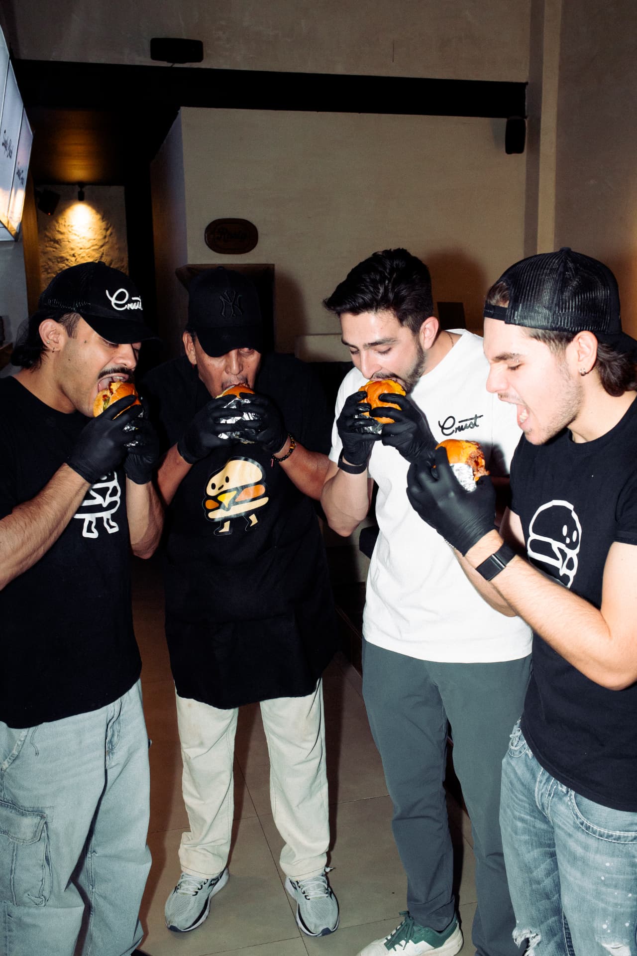 Equipo de Crust mordiendo smash burgers en la sucursal